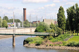 01192_5851 Blick von den Norderelbbrcken zum Haken in Hamburg Rothenburgsort. Rechts Bume und Rasenflche vom Elbpark Entenwerder und hinter der Fussgngerbrcke ber das ehemalige Hafenbecken die Netze der Golfanlage und der Wasserturm / Wasserspiel der Hamburger Wasserwerke.