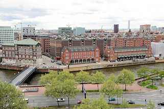 1453 Blick vom Dach des Chilehauses auf die Speicher und Zollgebude am Zollkanal in der Speicherstadt Hamburgs - im Hintergrund die moderne Architektur der Neubauten des neuen Hamburger Stadtteils Hafencity.