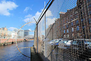 3172 Zollzaun mit Maschendraht am Zollkanal des Hamburger Freihafens - hinter dem Zaun Gebude der Speicherstadt und der Schriftzug der Hamburg Port Authority / HPA