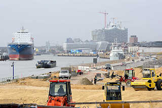 3192 Bauarbeiten am Kirchenpauerkai in der Hamburger Hafencity - Planierraupen schtten Sand auf; ein Binnenschiff fhrt elbabwrts - im Hintergrund die Baustelle der Elbphilharmonie.