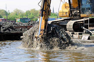 6541 Baggerschaufel mit Schlamm wird aus dem Spreehafen in Hamburg Wilhelmsburg / Kleiner Grasbrook herausgeholt - Baggerarbeiten im Hamburger Hafen.