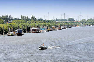 9259 Spreehafen in Hamburg Wilhelmsburg / Kleiner Grasbrook - Wohnboote liegen am Ufer des Hafens - eins Sportboot / Schlauchboot mit Aussenbordmotor fhrt Richtung Veddeler Kreuz, Mggenburger Zollhafen.