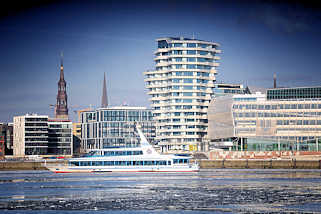 2761 Architektur der Hamburger Hafencity - Kirchturmspitzen hinter den modernen Neubauten den neuen Hamburger Stadtteils - Fahrgastschiff auf der Norderelbe.