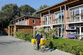 9165 Neubausiedlung / Passivhuser im Zassenhausweg - ein Brieftrger fhrt mit seinem Postfahrrad die Zustelltour.