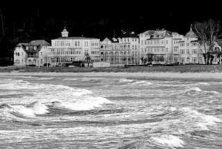 5633 Wellen und Gischt - windiger / strmischer Tag an der Ostsee - im Hintergrund die Strandpromenade mit Gebuden.