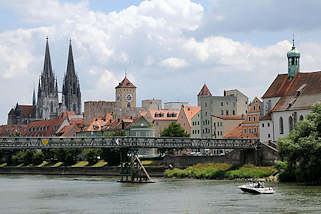 2979 Panorama der Altstadt von Regensburg - lks. die Trme des St. Peter Doms, in der Bildmitte der Uhrturm des alten Rathauses; rechts die evangelisch lutherische Kirche St. Oswald. Ein Motorboot fhrt auf der Donau beim eisernen Steg.