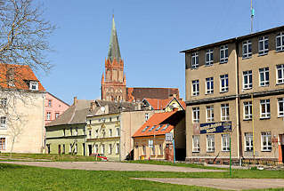4487 Wohnhuser, einstckig - mehrstckig - schlichte Architektur; hinter den Husern die Backsteinarchitketur der Marienkirche Trzebiatow / Treptow an der Rega.